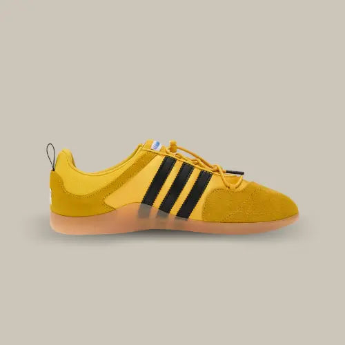 La Adidas Ballerina Bad Bunny Bold Gold vue de côté avec sa base jaune et ses trois bandes de couleurs noirs.