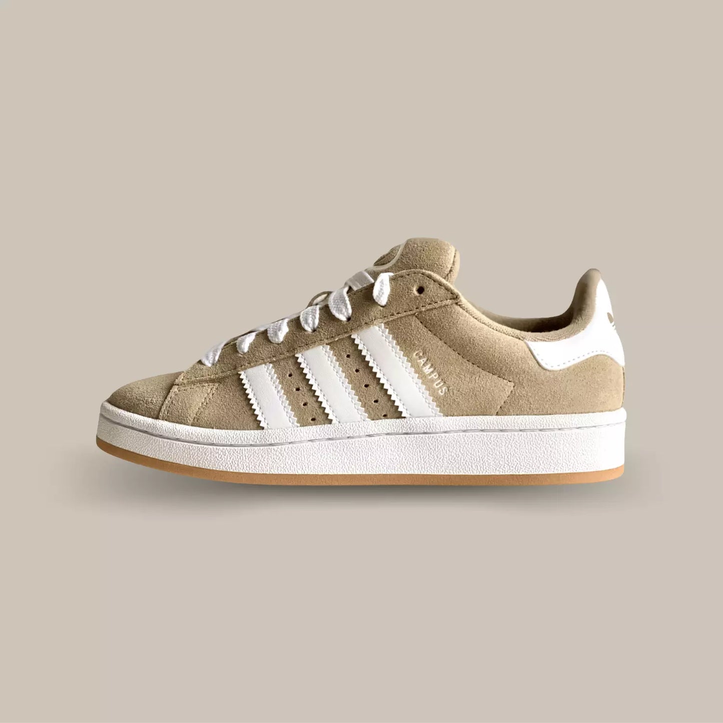 La adidas campus 00s beige cloud de profil avec sa couleur beige, ses trois épaisses bandes blanches et sa semelle en gomme