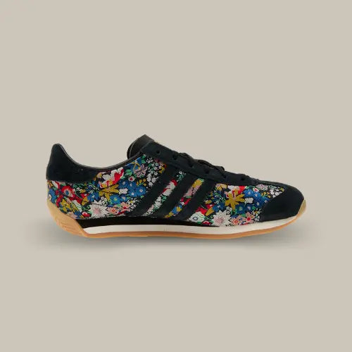 La Adidas Country OG Liberty London Floral Embroidery vue de côté avec sa base en toile recouvert de leur et les trois bandes de couleur noir accordées au heel tab.