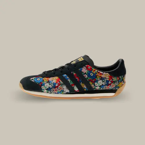 La Adidas Country OG Liberty London Floral Embroidery vue de côté avec sa base en toile recouvert de leur et les trois bandes de couleur noir accordées au heel tab.