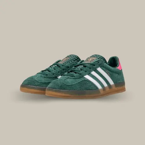 La Adidas Gazelle Indoor Collegiate Green Lucid Pink de coté avec sa base en suède vert sapin, ses trois bandes en cuir blanc, son talon rose et sa semelle en gomme transparente.
