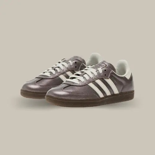La Adidas Samba OG Metallic Purple revisite l’un des classiques intemporels d’Adidas avec une touche futuriste et audacieuse. Sa tige en cuir métallisé violet apporte un éclat unique, contrasté par les trois bandes en cuir blanc cassé qui rappellent l’héritage footballistique de la Samba. Son col rembourré et sa semelle en gomme semi-transparente assurent un confort optimal et une adhérence parfaite.