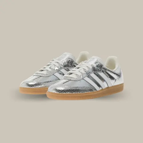 Brillez comme jamais avec la Adidas Samba OG Silver Metallic Cracked Leather, une version électrisante de l’iconique silhouette Samba ! Avec sa tige en cuir argenté métallisé à effet craquelé, cette sneaker transforme un classique du football en véritable pièce de mode. Le contraste saisissant avec les trois bandes blanches, le logo Samba noir et la semelle gomme rétro en fait un modèle à la fois audacieux et intemporel.