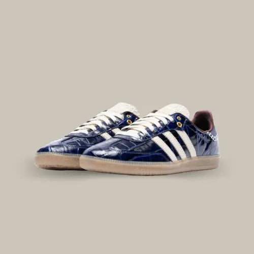 La Adidas Samba Wales Bonner Navy Croc est le résultat d'une collaboration raffinée entre Adidas et la créatrice britannique Wales Bonner, alliant style rétro et sophistication contemporaine. Revisité dans un cuir verni bleu marine avec un motif croco, ce modèle emblématique des années 1950 prend une allure luxueuse et unique. Les trois bandes beiges contrastent élégamment avec le cuir texturé, tandis que des détails comme la languette en tissu texturé et les œillets dorés ajoutent une touche vintage.