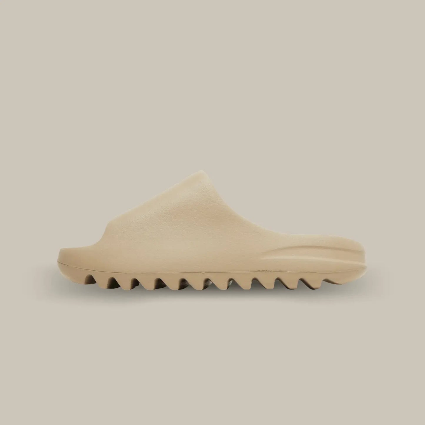 La Yeezy Slide Pure de coté, cette claquette avec son coloris monochrome beige our et sa structure en mousse EVA.