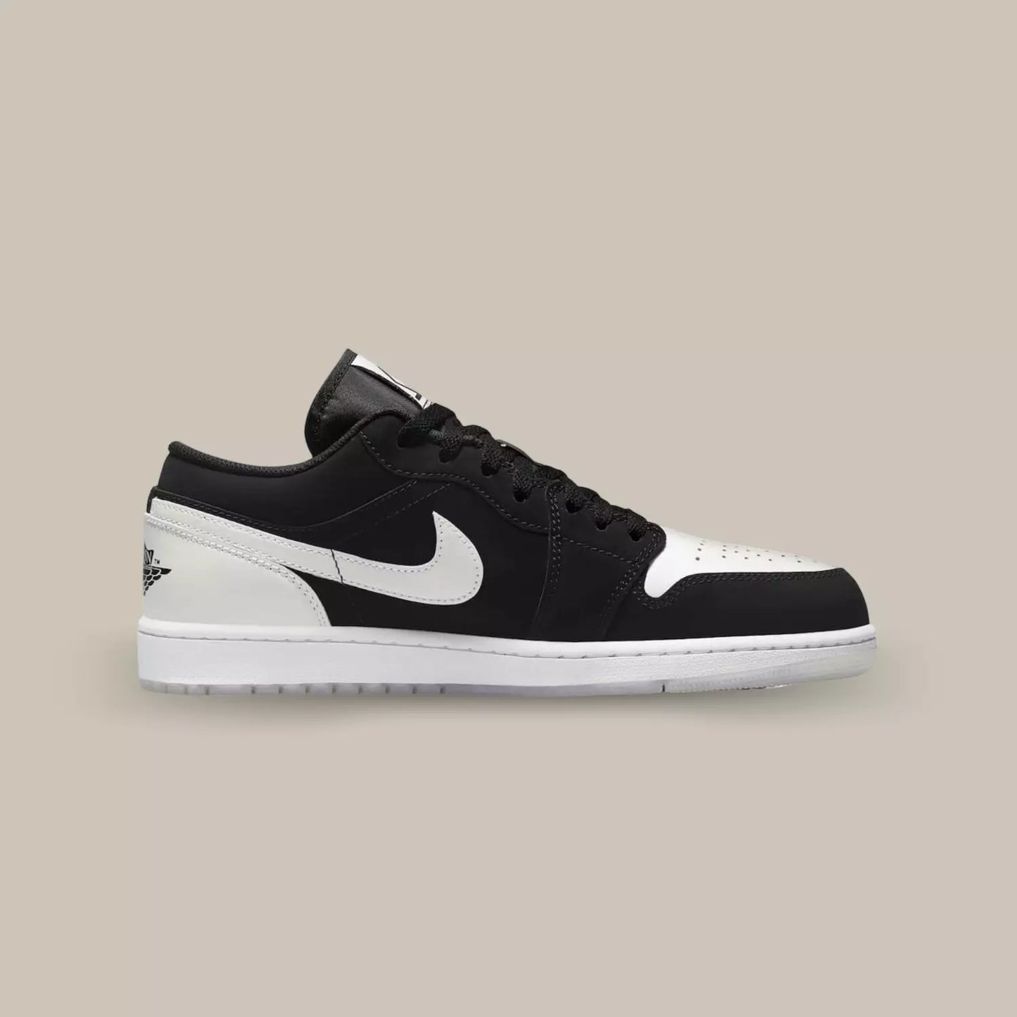 La Jordan 1 Low Black White Diamond de coté avec une base en nubuck noir et des éléments en cuir blanc sur le swoosh, la toebox et le talon.