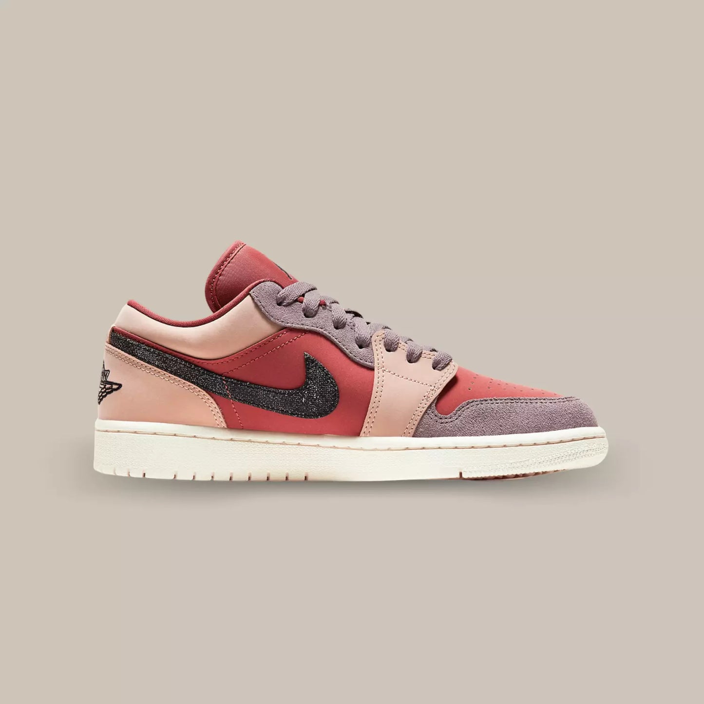La Jordan 1 Low Canyon Rust de coté composé d’empiècements en cuir et en suède de plusieurs couleurs, rose pale, rouge et mauve.