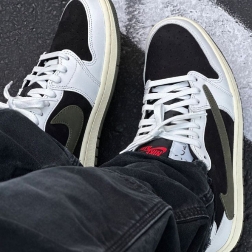 La Air Jordan 1 Low Retro OG SP Travis Scott Olive portée avec un jean noir.