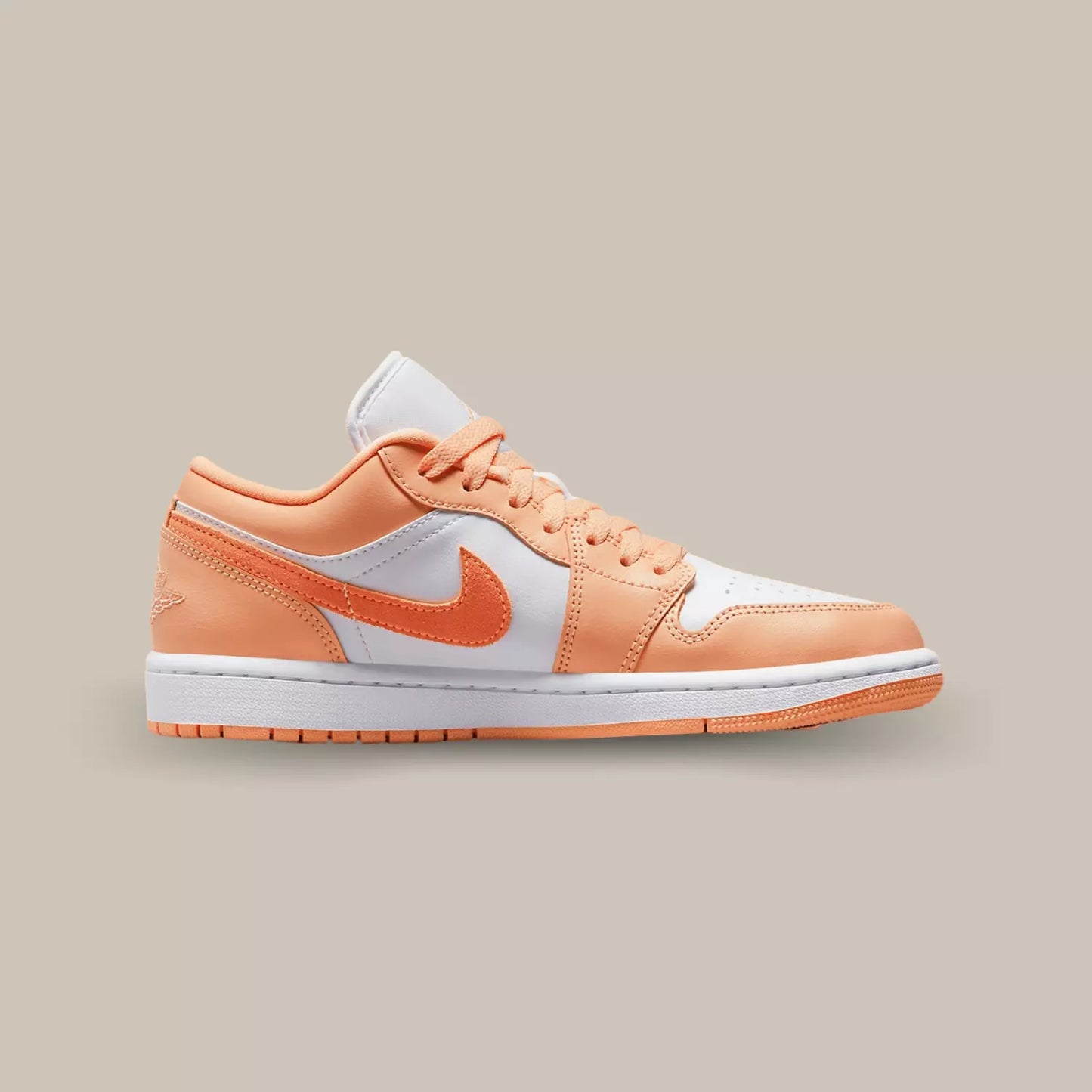 La Jordan 1 Low Washed Denim de coté avec sa base de couleur blanche et ses empiècements en cuir pêche.