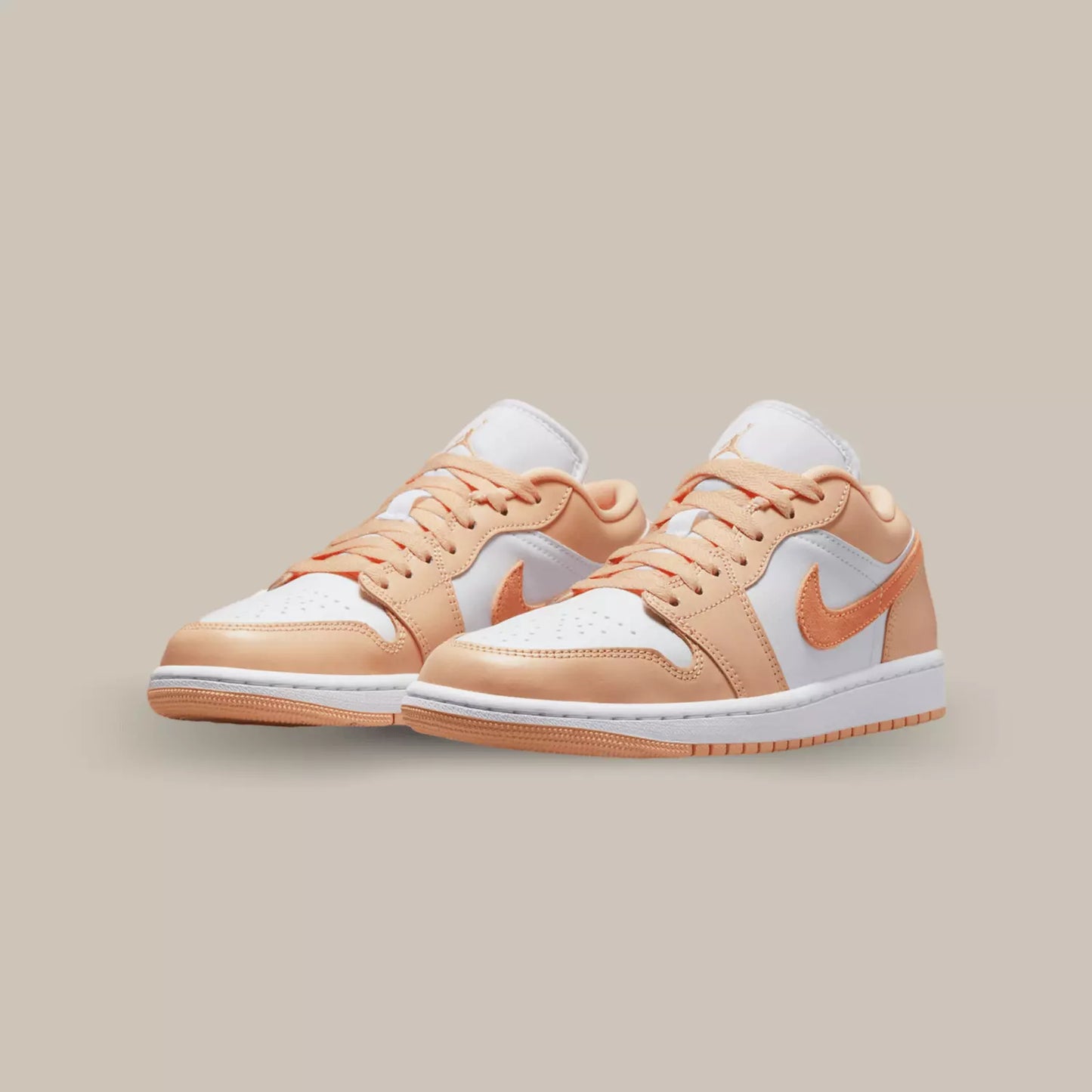 Cette Jordan 1 Low Sunset Haze propose une base en cuir blanc avec des empiècements en cuir pêche. On retrouve un swoosh en suède orange sur les cotés.