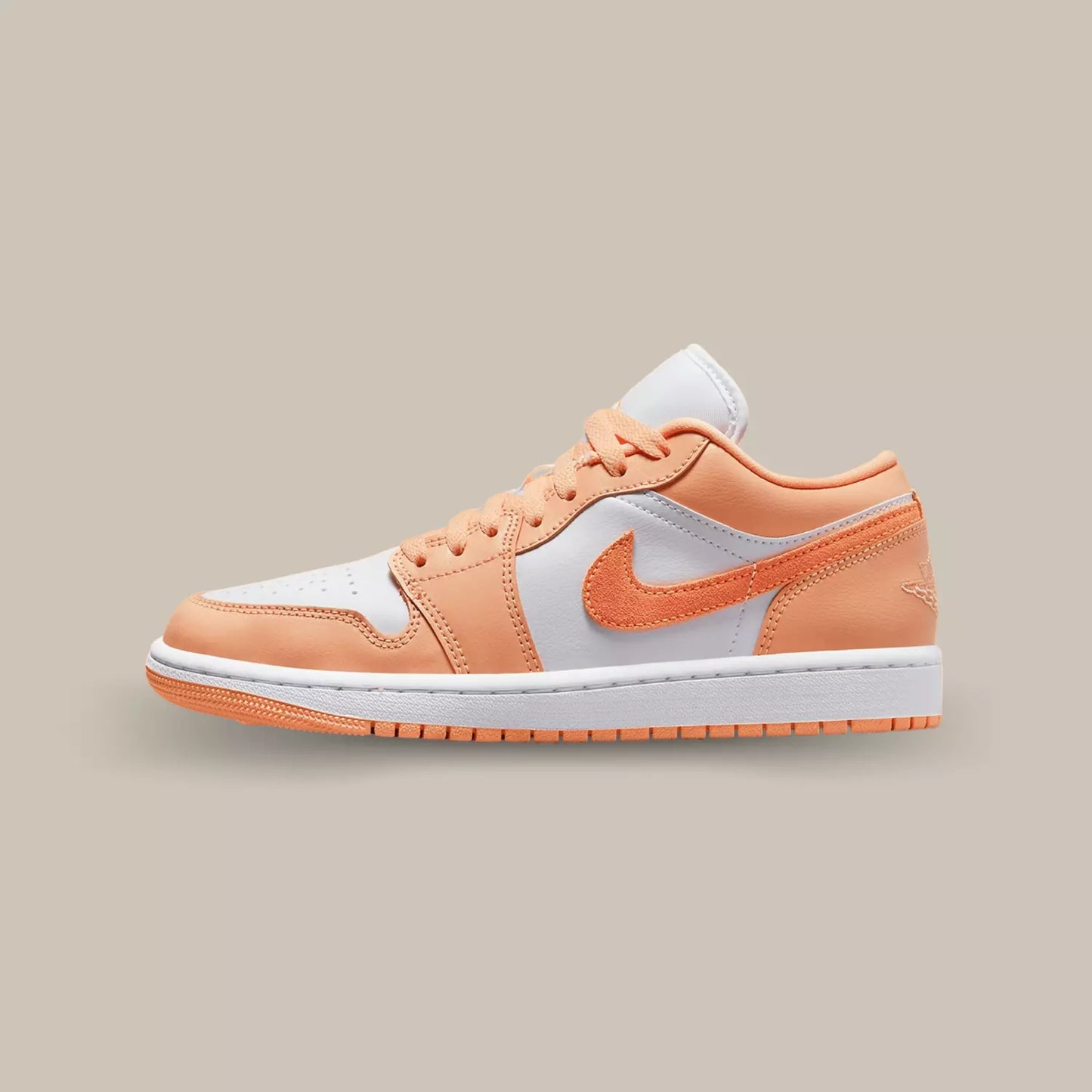 La Jordan 1 Low Washed Denim de coté avec sa base de couleur blanche et ses empiècements en cuir pêche.