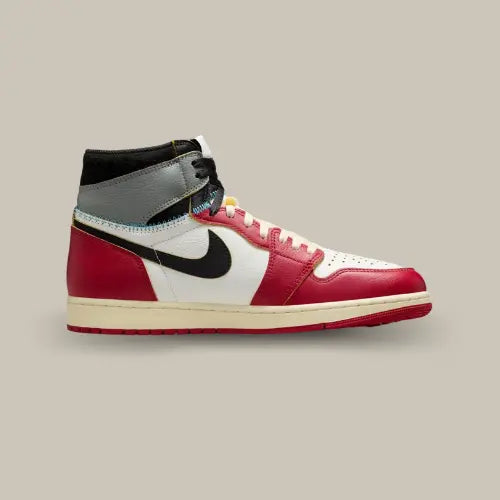 La Air Jordan 1 Retro High OG SP Union LA Chicago Shadow vue de côté avec sa base en cuir blanc blanc et ses empiècement rouge. On retrouve un swoosh noir et un empiècement gris comportant le logo Air Jordan noir au niveau de la cheville.