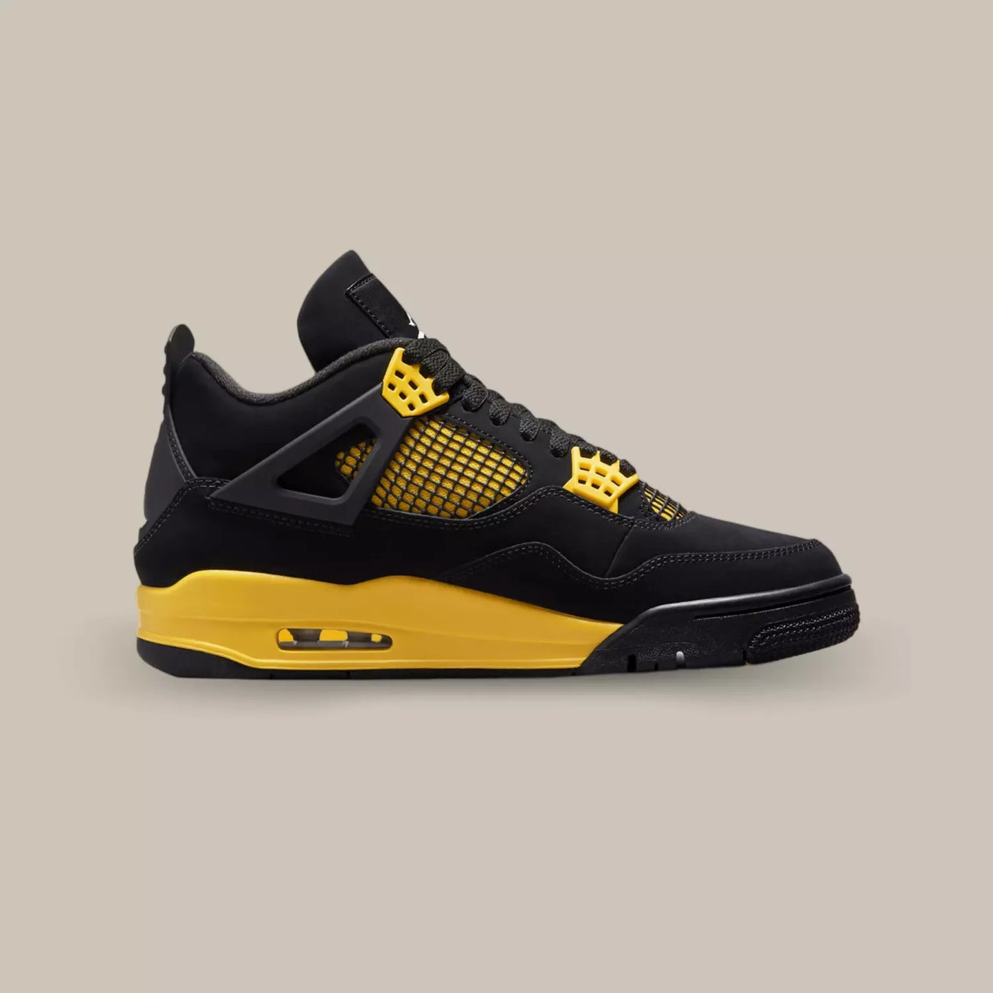 La Air Jordan 4 Retro Thunder de coté avec sa base en nubuck noir, sa cage jaune et noir et ses œillets jaunes.