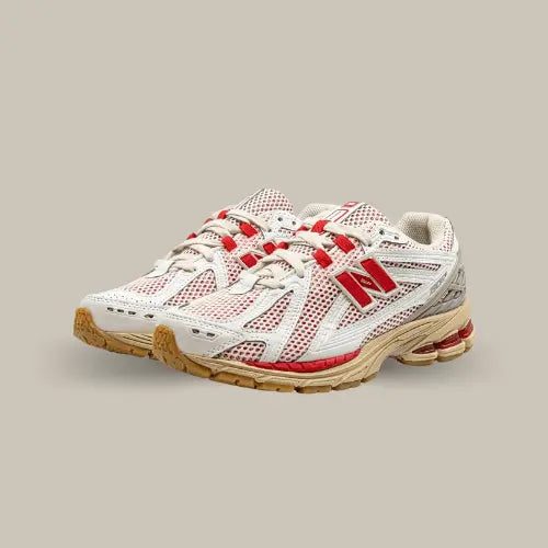 La New Balance 1906R White Red possède une base en mesh blanc avec des superpositions ton-sur-ton. Un empiècement en TPU gris vient renforcer le talon et le logo "N" de couleur rouge vient contraster le modèle.