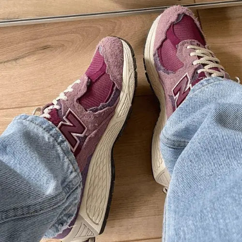 La New Balance 2002R Protection Pack Pink portée avec un jean bleu clair.