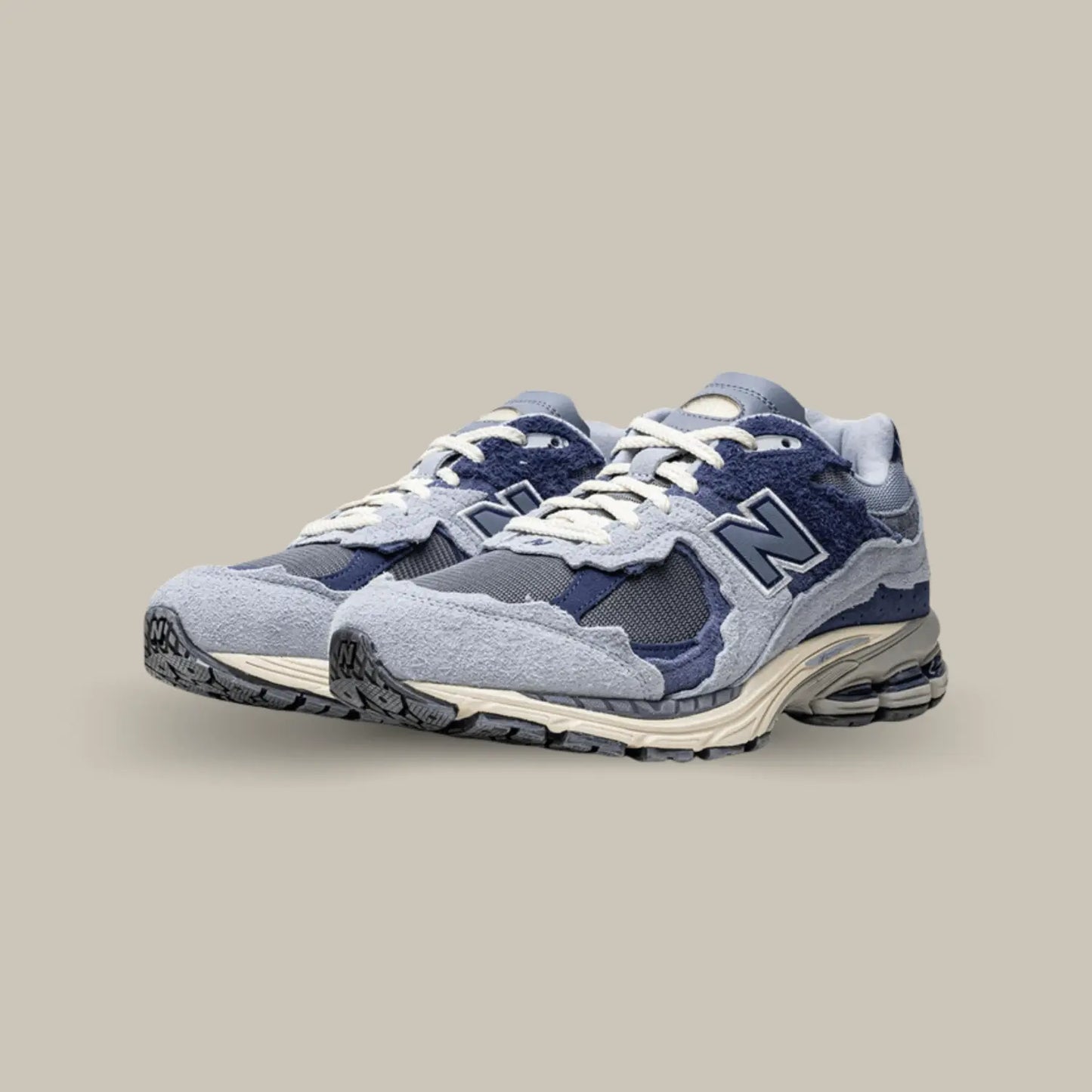 La New Balance 2002R Protection Pack Light Arctic Grey Purple présente une base qui associe mesh, cuir lisse et suède. Cette nouvelle version présente un design penchant vers des coloris violet.
