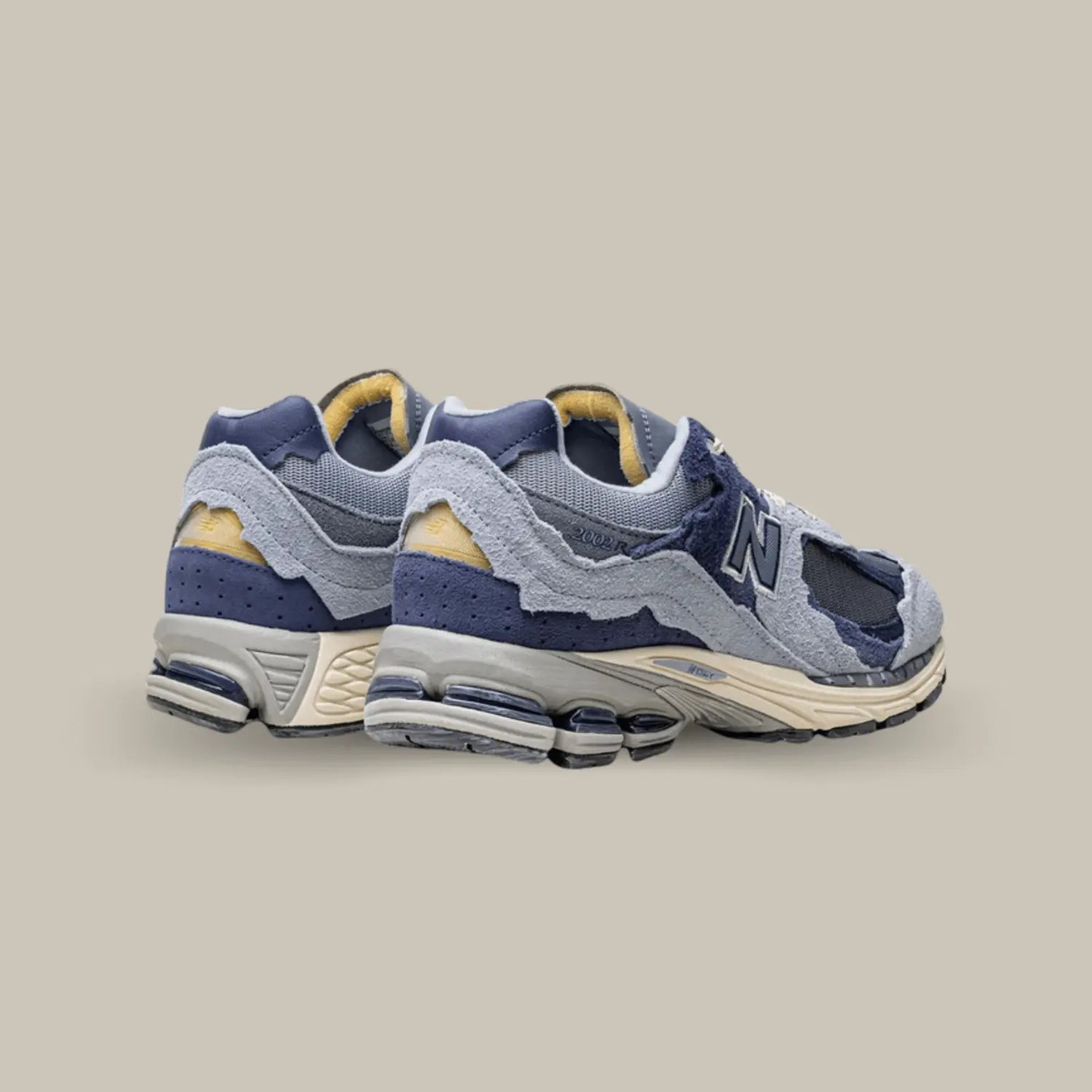 La New Balance 2002R Protection Pack Light Arctic Grey Purple de dos avec une base qui associe mesh, cuir lisse et suède. Cette nouvelle version présente un design penchant vers des coloris violet.