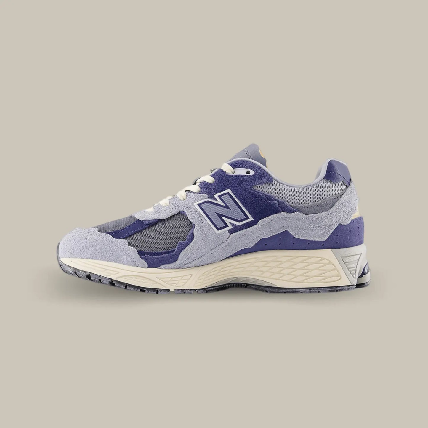 La New Balance 2002R Protection Pack Light Arctic Grey Purple de coté avec une base qui associe mesh, cuir lisse et suède dans un coloris entre le violet et le bleu.