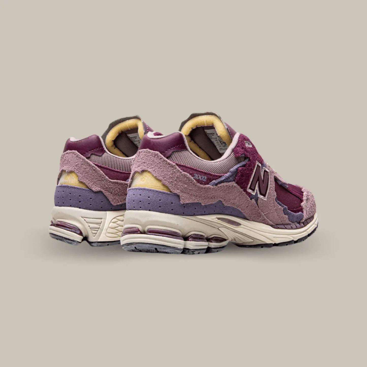 La New Balance 2002R Protection Pack Pink de dos avec une base qui associe mesh, cuir lisse et suède. Cette nouvelle version présente un design penchant vers des coloris rose.