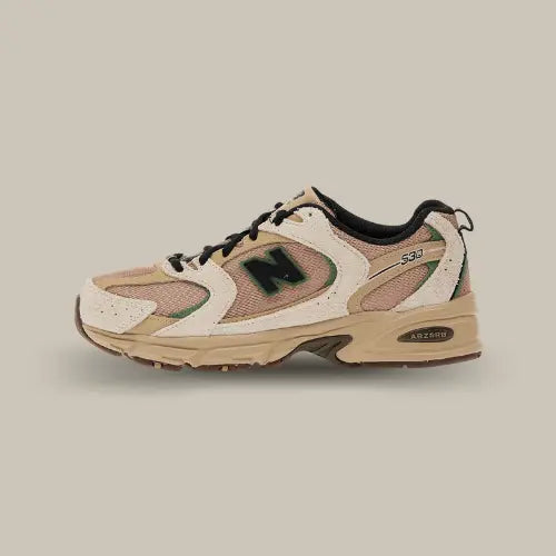 La New Balance 530 Linen Encensvue de cté avec sa base marron et ses empiècements biege. On retrouve le logo "N" noir et le système ABZORB dans une semelle ton sur ton.