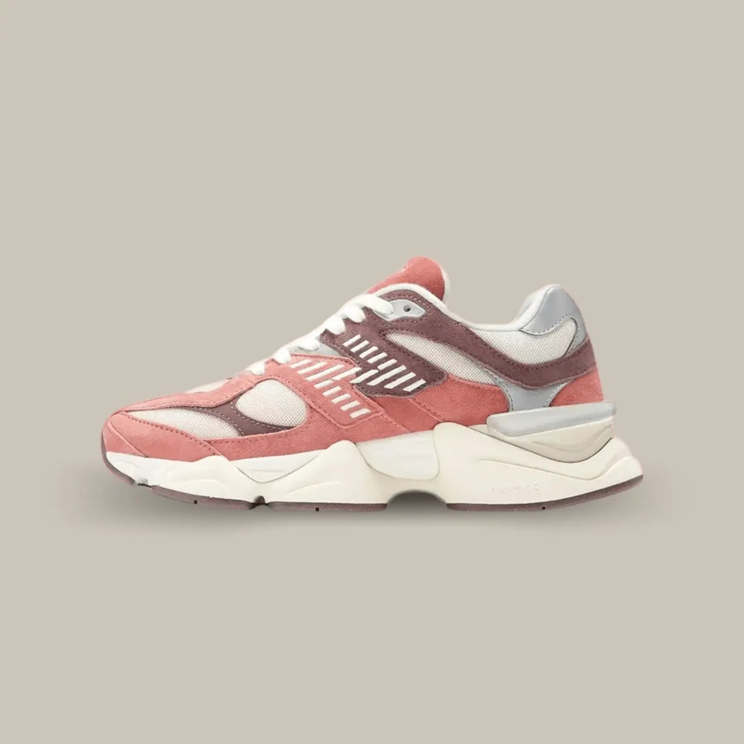 La New Balance 9060 Sea Salt Cherry Blossom avec une base en mesh rose clair, surmontée d’empiècements en suède rose et marron.