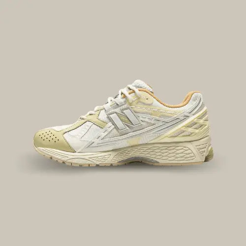 La New Balance 1906U Lunar New Year Cream vue de côté avec sa base en mesh blanc et ses empiècements en cuir, TPU et nylon de couleur beige.