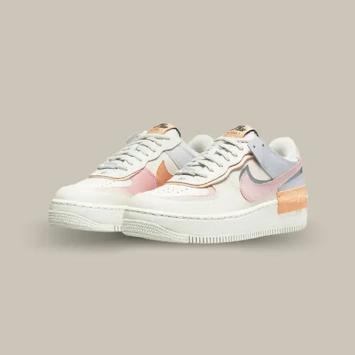 La Nike Air Force 1 Shadow Pink Glaze possède une base en cuir blanc vieilli avec des touches de pastel. On retrouve un double swoosh qui vient donner du relief à la paire et des accents noirs qui viennent contraster avec les tons plus doux de la paire.