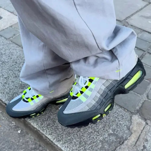 La Nike Air Max 95 OG Big Bubble Neon portée avec un pantalon large gris.