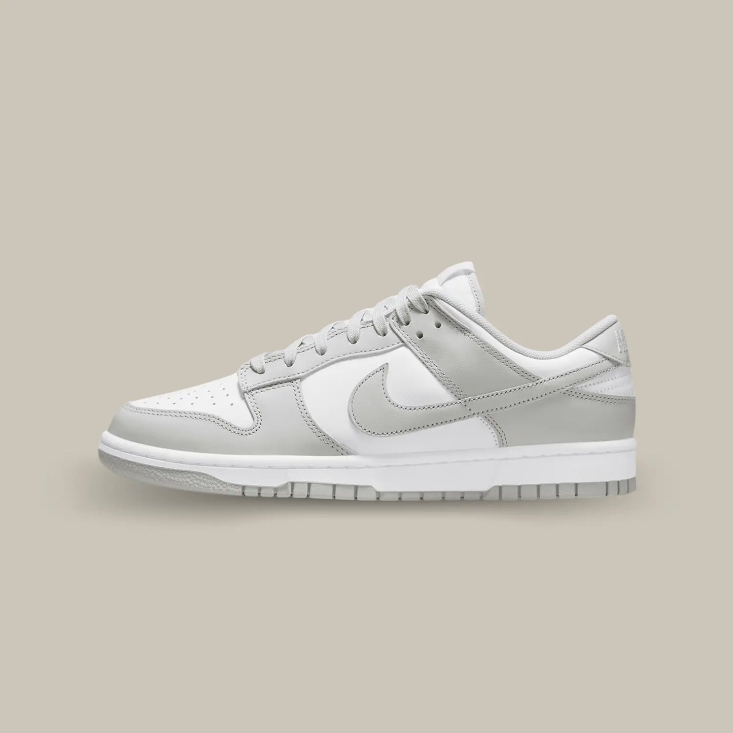 La Nike Dunk Low Grey Fog de coté avec son empeigne en cuir blanc, relevée d’empiècements en cuir gris clair.