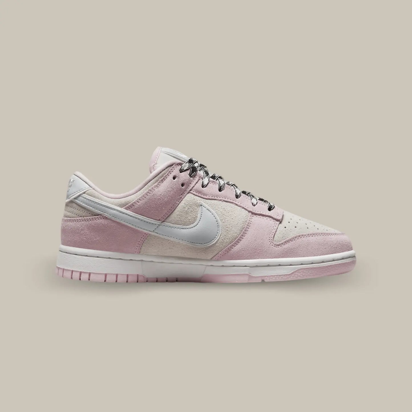 La Nike Dunk Low LX Pink Foam de coté avec son empeigne daim partagée entre le beige et rose et avec un swoosh en cuir gris.