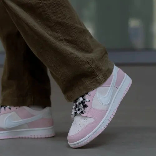 La Nike Dunk Low LX Pink Foam portée avec un pantalon vert kaki.