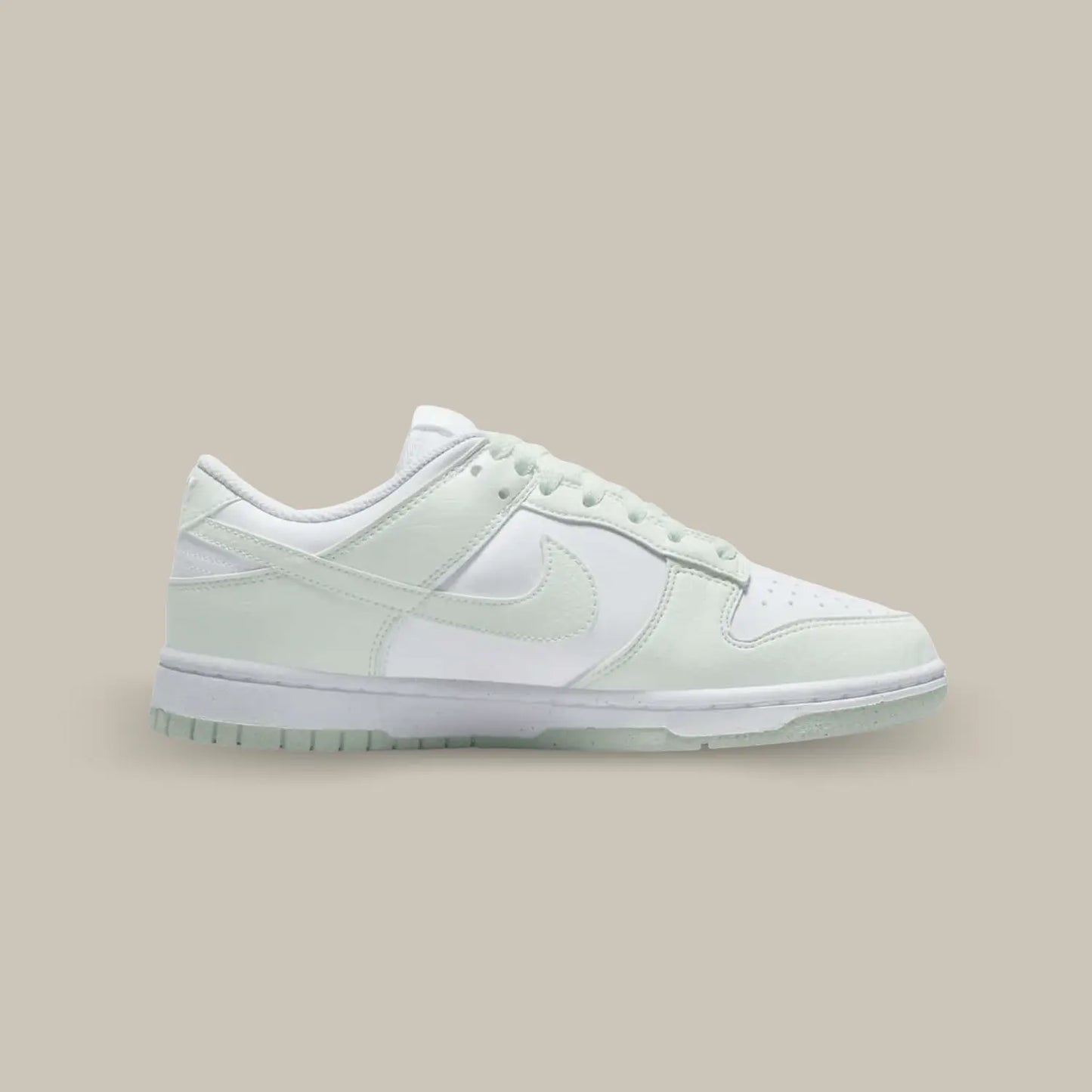 La Nike Dunk Low Next Nature White Mint de coté avec sa tige en cuir blanc recyclé qui se voit rehaussée par des empiècements en cuir craquelé de couleur vert pastel.
