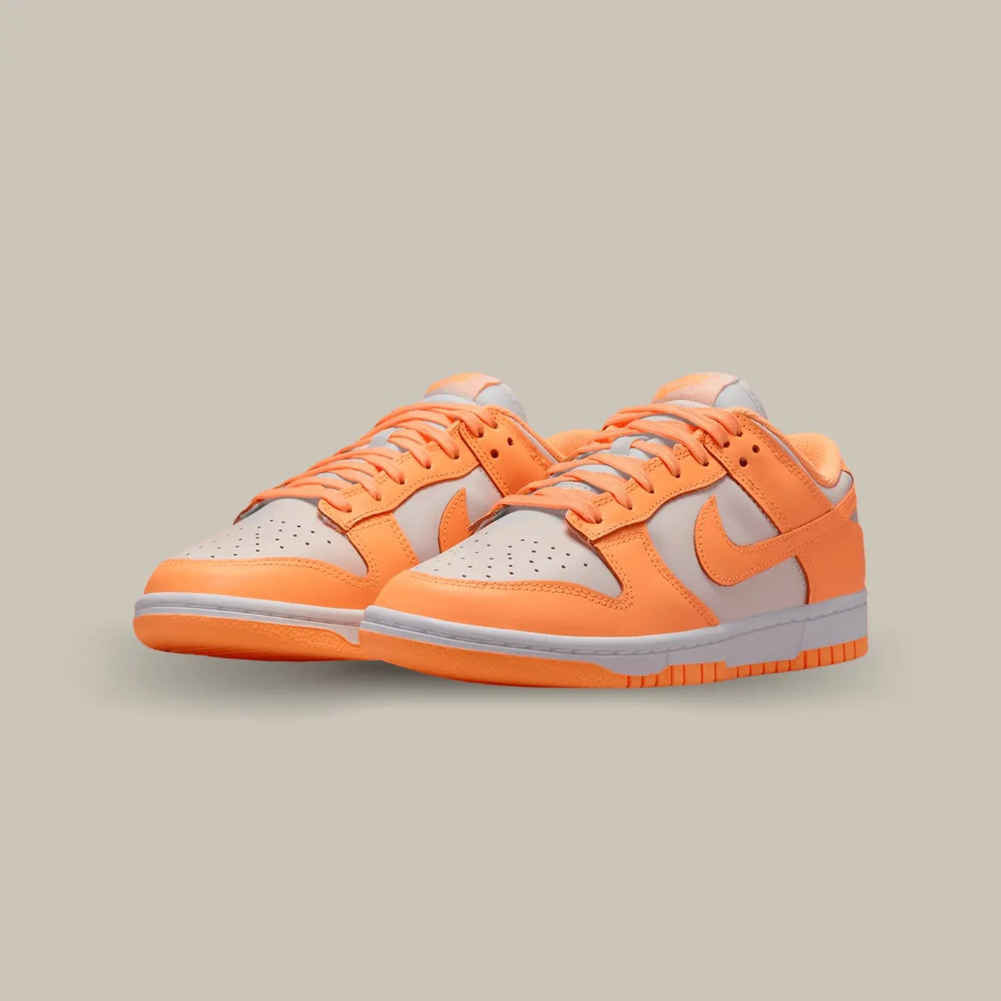 La Nike Dunk Low Peach Cream dévoile une base en cuir crème à la teinte douce. Plusieurs éléments de cuir orange s’ajoutent à la structure et nous rappelle le code couleur d’une pêche.
