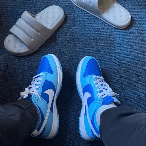 La Nike Dunk Low QS Argon portée avec un pantalon noir.