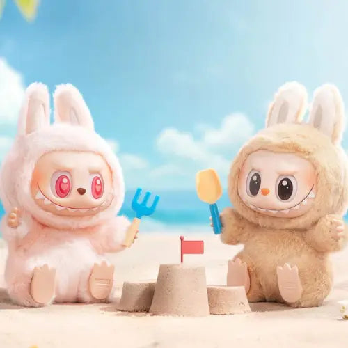 Figurines Pop Mart Labubu Have a Seat – modèles Dada et Baba construisant un château de sable sur la plage, collection The Monsters en blind box.