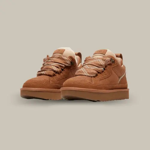 La UGG Lowmel Chestnut est parfaite pour allier confort et style cet hiver. Avec sa tige en suède doux dans un coloris Chestnut chaud et naturel, elle offre une esthétique à la fois élégante et décontractée. Conçue pour un maximum de confort, cette paire est dotée d’une doublure en laine moelleuse appelée UGGPLUSH, idéale pour les journées froides. Ses lacets en fibres de polyester recyclé et sa semelle épaisse en EVA issu de la canne à sucre ajoutent une touche outdoor à ce modèle urbain.