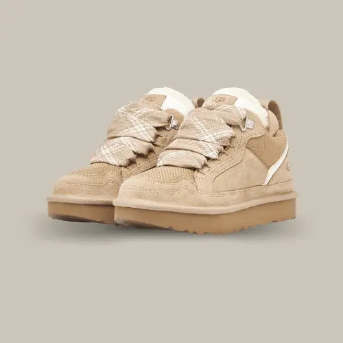 La UGG Lowmel Sand est la sneaker parfaite pour un hiver stylé et confortable. Avec sa tige en suède beige sable et ses détails en maille, elle allie parfaitement chaleur et élégance décontractée. La doublure en laine UGGPLUSH garde vos pieds bien au chaud, tandis que la semelle épaisse en EVA offre durabilité et adhérence. Ses lacets robustes en fibres de polyester recyclé et son look outdoor chic en font une paire idéale pour toutes vos sorties, que ce soit en ville ou à la campagne.