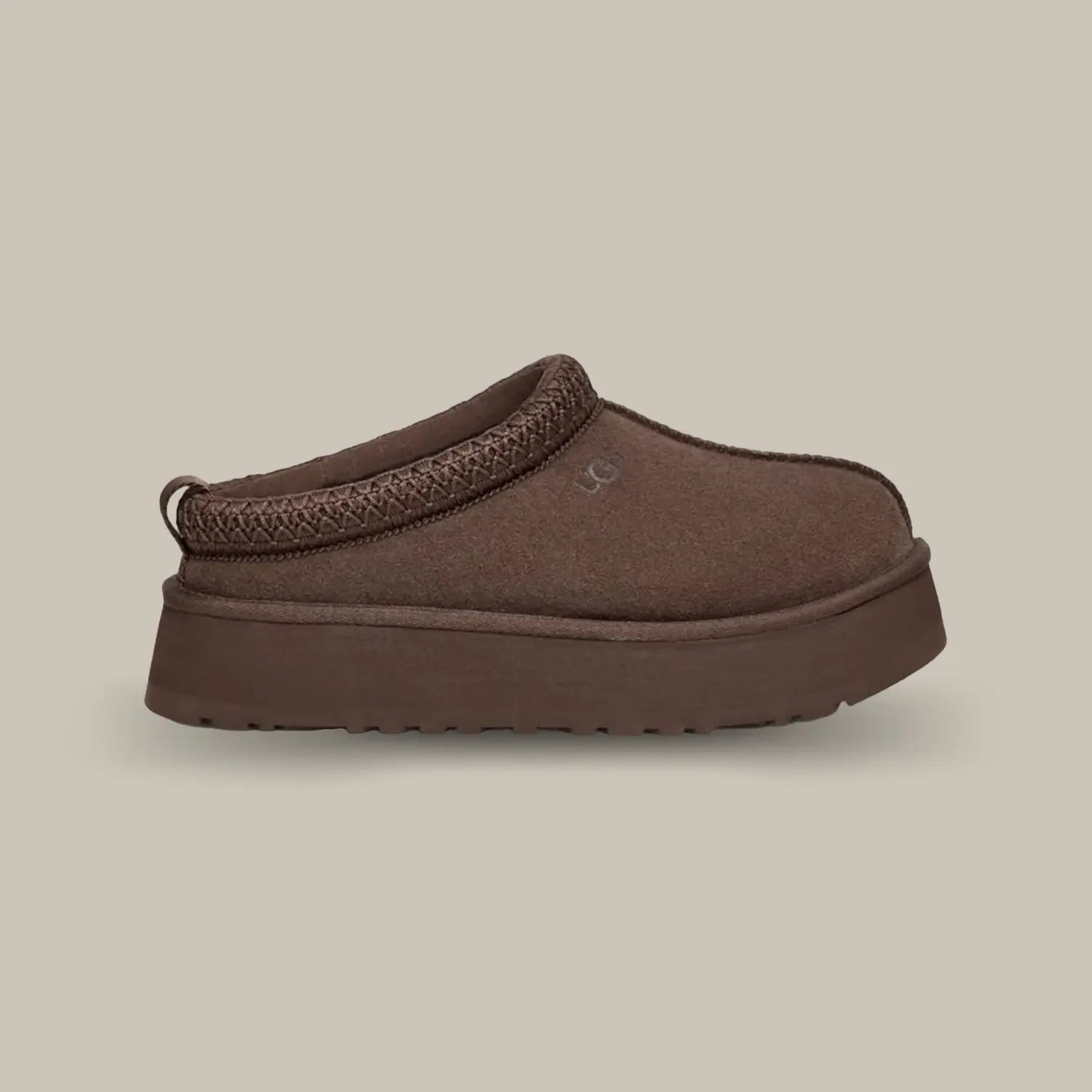La Ugg Tazz Chocolate de coté avec son empeigne en daim marron foncé, une tresse en polyester recyclé ton sur ton et une semelle compensée de 3.8 cm