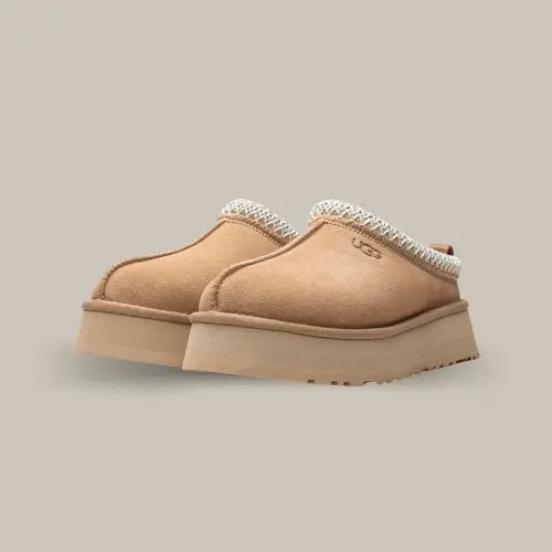 La UGG Tazz Sand incarne l'élégance décontractée et le confort ultime. Cette Tazz revisite la célèbre silhouette de la mule Tasman, avec une plateforme de 3.8 cm qui ajoute une touche moderne et audacieuse. Sa teinte couleur sable s’adapte à toutes vos tenues, des looks cosy à vos sorties en ville.
Fabriquée à partir de suède de haute qualité et doublée en laine UGGplush, elle offre une chaleur et un confort inégalés. Sa tresse brodé emblématique souligne l'héritage artisanal de la marque.