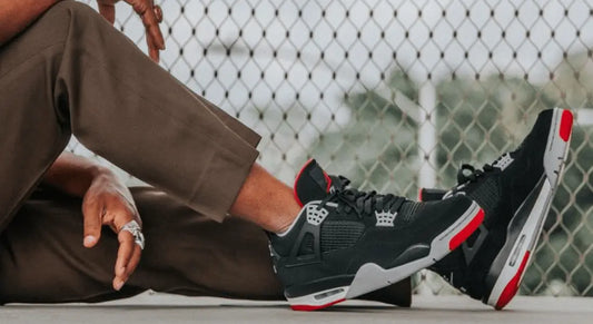 La Air Jordan 4 Retro Bred Reimagined portée avec un pantalon beige.