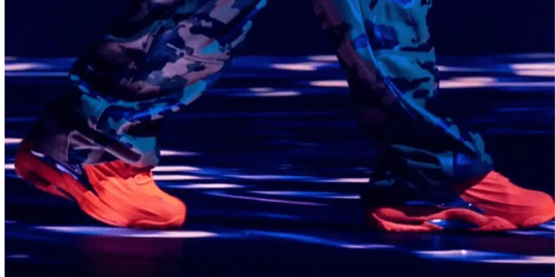 Drake portant une paire de Nike Hot Step 2 Nocta Total Orange pendant un concert.
