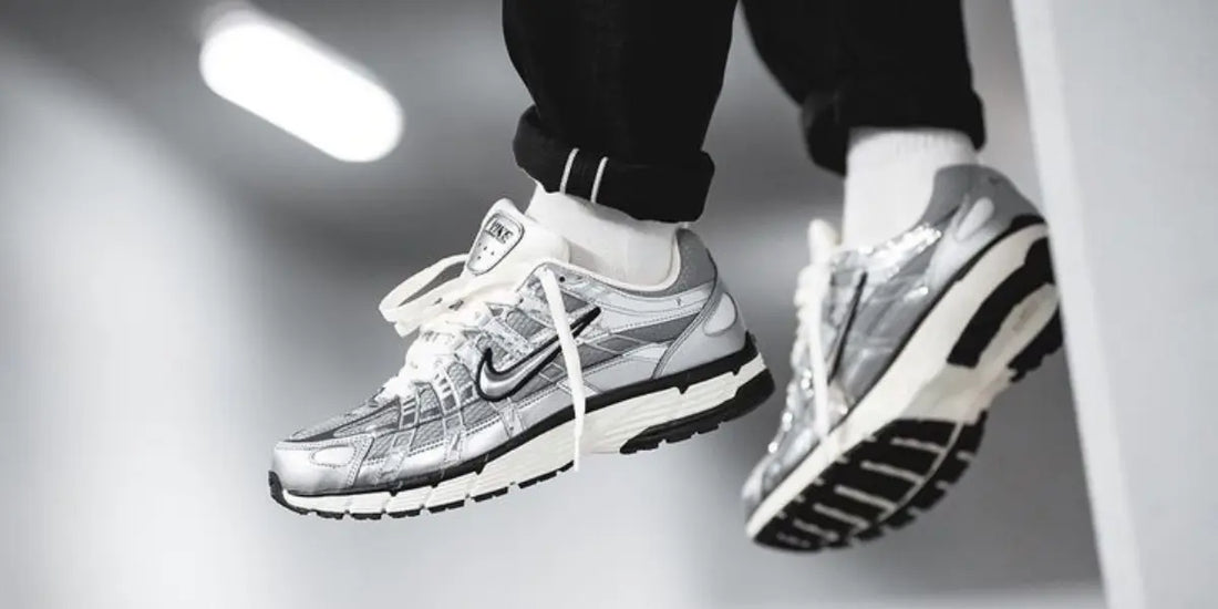 La Nike P-6000 Metallic Silver portée avec un pantalon noir.