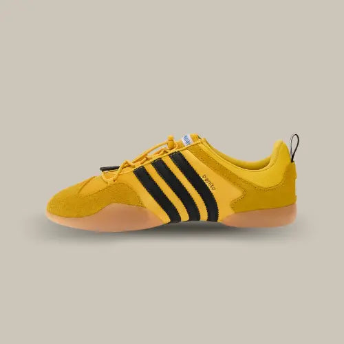 La Adidas Ballerina Bad Bunny Bold Gold vue de côté avec sa base jaune et ses trois bandes de couleurs noirs.