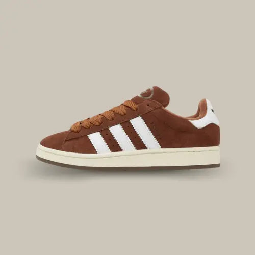 La Adidas Campus 00s Bark possède une base en suède marron accompagnée des trois célèbres bandes blanches accordées au heel tab. Ce modèle est composé d'un semelle jaunie qui donne un aspect vintage.