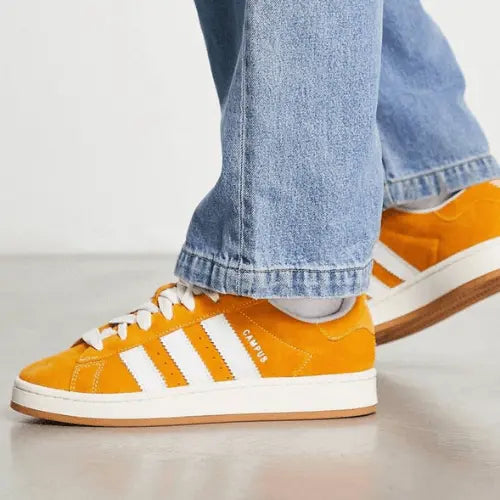 La Adidas Campus 00s Pantone Cloud White portée avec un jean bleu clair.