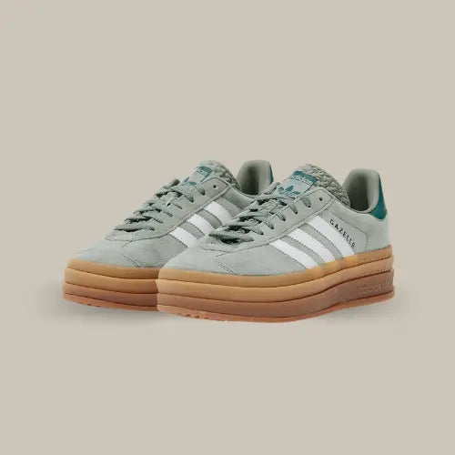 La Adidas Gazelle Bold Silver Green possède une tige en suède vert avec les trois bandes en cuir blanc. On retrouve une épaisse semelle en gomme de caoutchouc et le branding "Gazelle" doré sur le sur le côté.