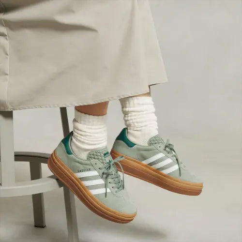 La Adidas Gazelle Bold Silver Green porté avec des chaussettes épaisses et une jupe longue verte clair.