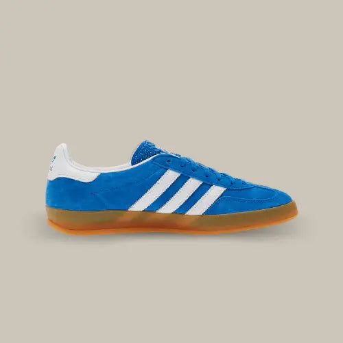 La Adidas Gazelle Indoor Blue Bird Gum de coté avec sa couleur bleu, ses trois bandes blanches et sa semelle en caoutchouc.