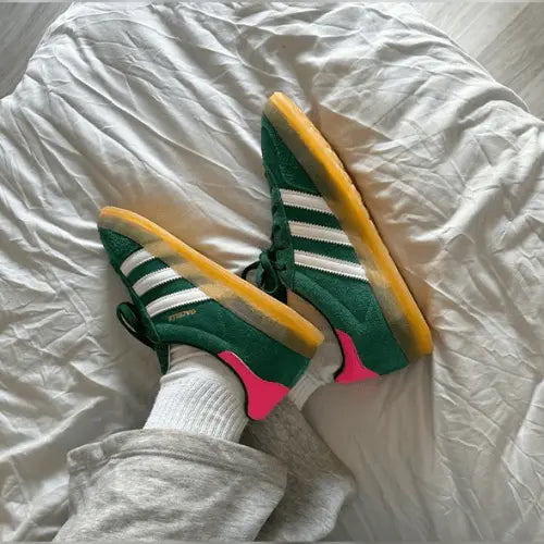 La Adidas Gazelle Indoor Collegiate Green Lucid Pink portée avec un jogging gris.