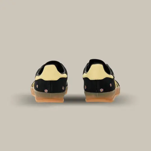 L'arrière de la Adidas Gazelle Indoor Core Black Almost Yellow Floral avec sa base en daim noir parsemées de petites fleurs et son heel tab jaune.
